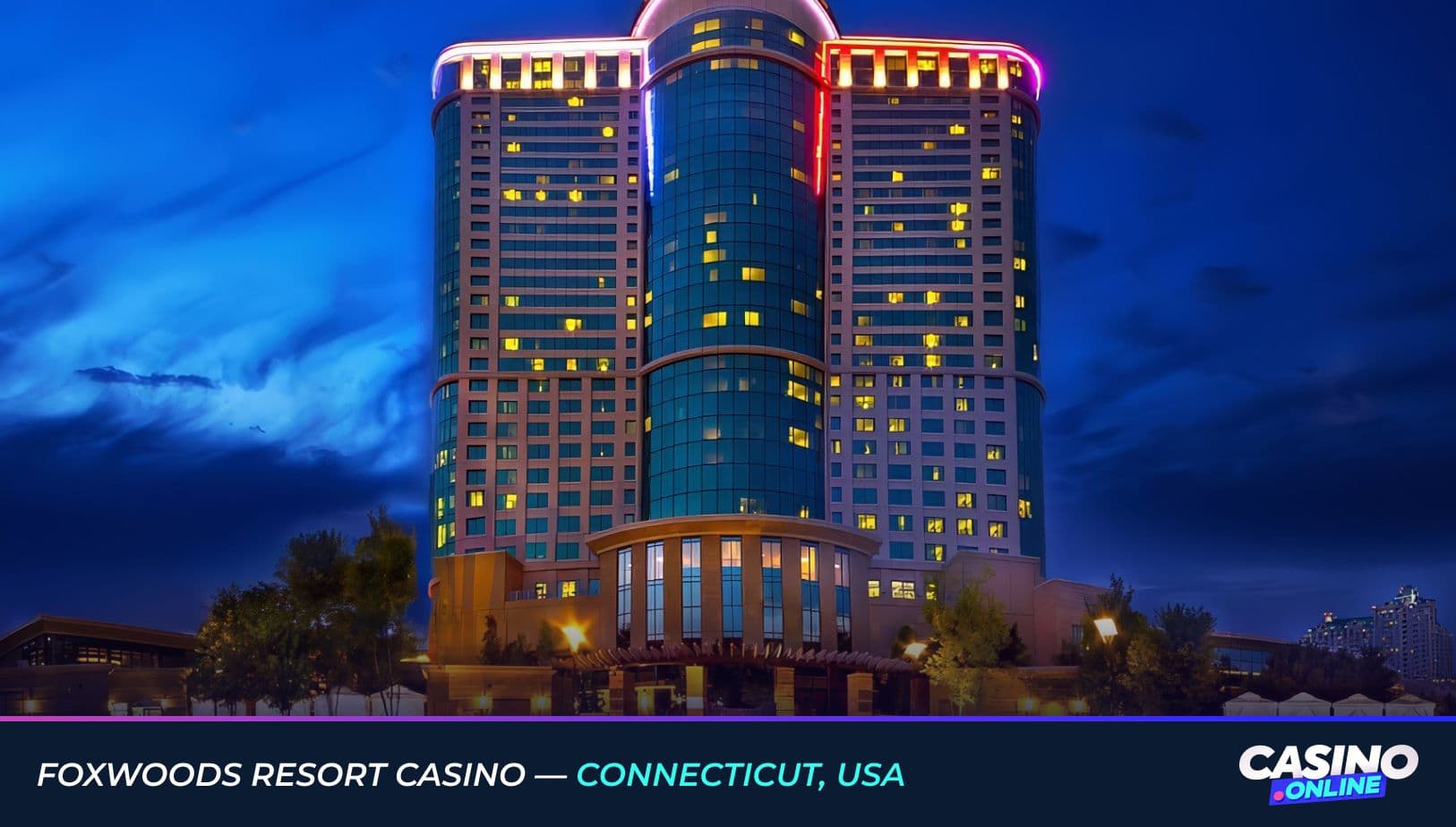 Night view of Foxwoods Resort Casino in Connecticut, USA, featuring the illuminated modern hotel tower against a deep blue sky.