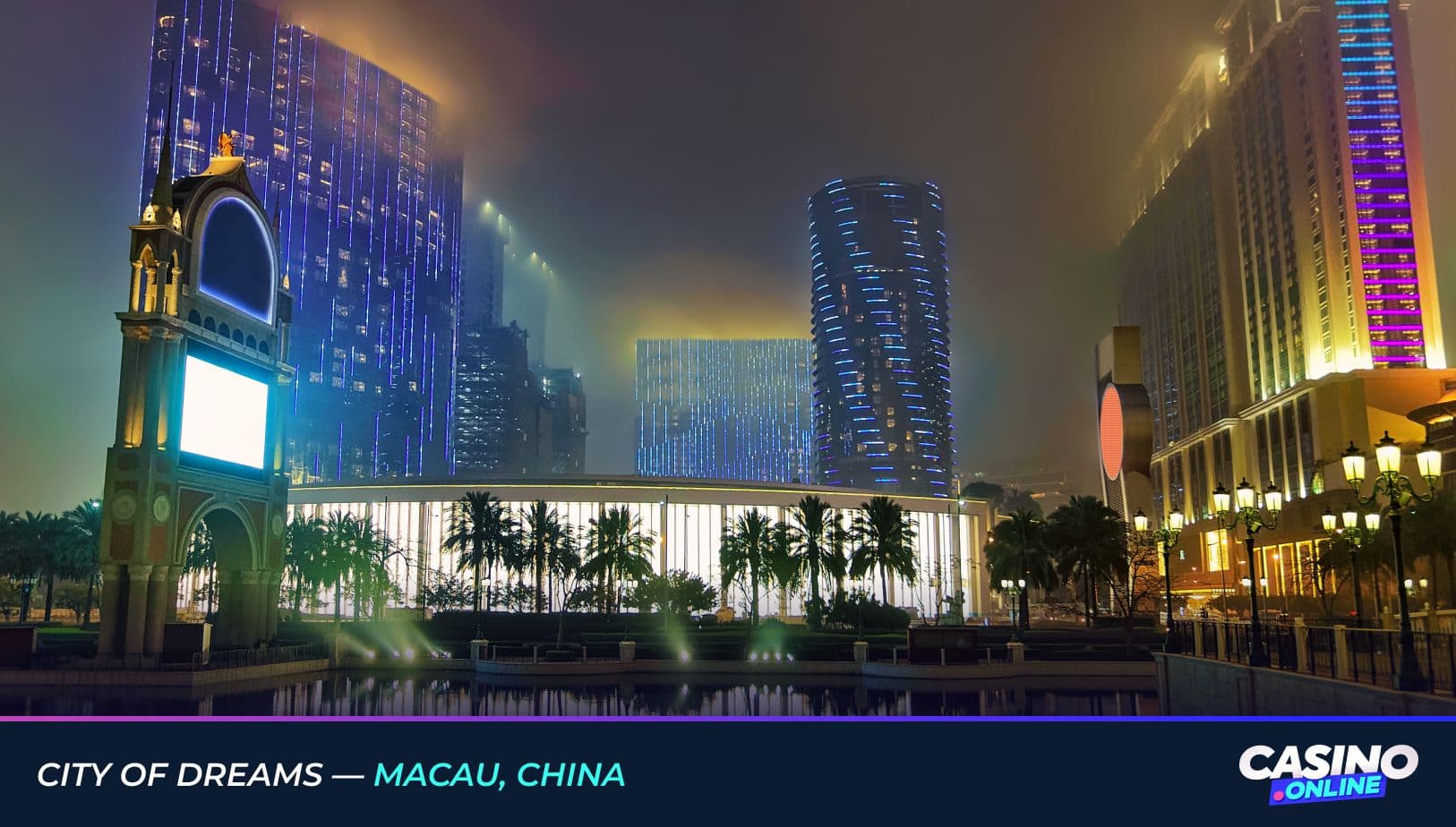 Nighttime view of City of Dreams in Macau, China, featuring illuminated modern towers, palm trees, and vibrant architectural lighting in a misty atmosphere.