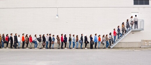 A line of people waiting to get inside a building.